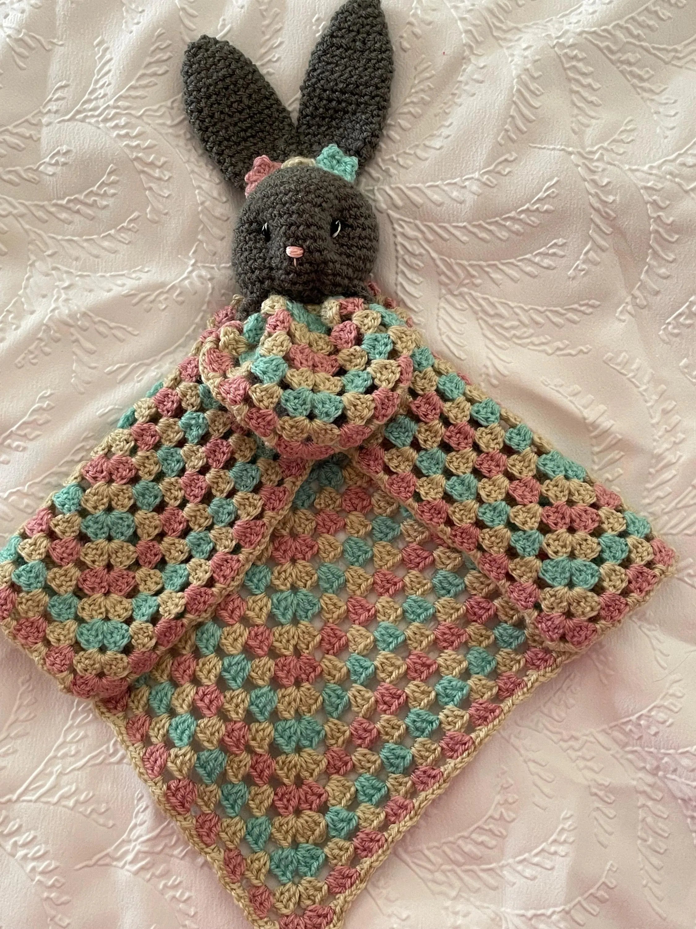 Baby snuggling with crochet comforter blanket UK