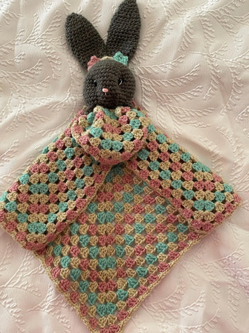 Baby snuggling with crochet comforter blanket UK