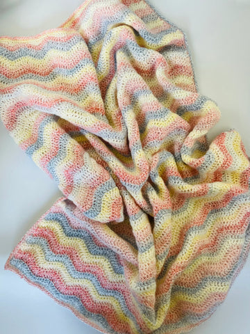 Soft newborn baby blanket folded on crib

Cozy ripple pattern baby swaddle blanket UK

Handmade newborn blanket baby shower gift

Lightweight warm infant blanket in pastel colors

Baby wrapped in soft swaddle crib blanket