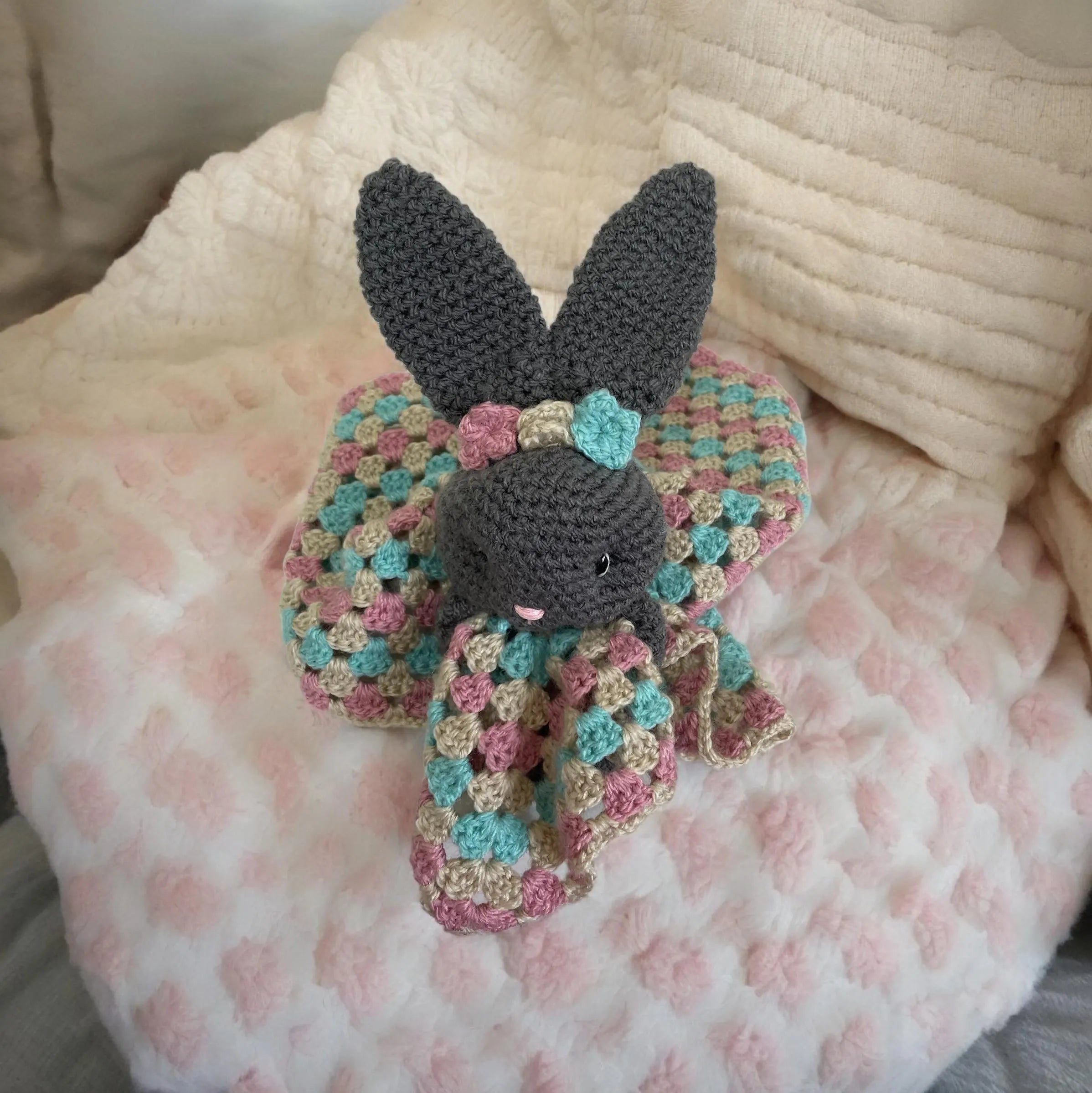 Gentle baby comforter crochet blanket folded on crib